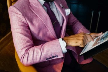 Man in a pink suit using a tablet computer